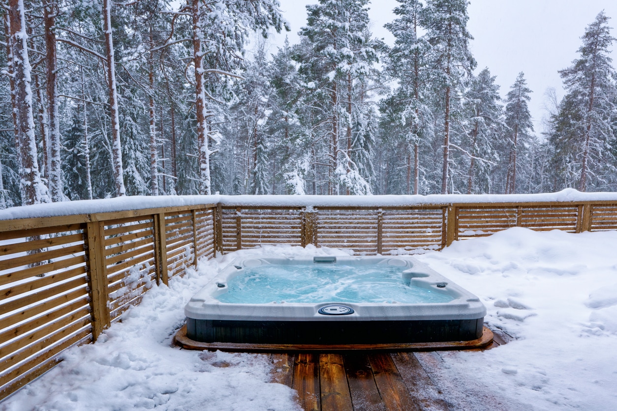 Hot tub situated in snowy forest, ready for use